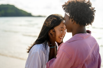 Interracial couple enjoying a romantic beach getaway, embracing love, laughter, and togetherness
