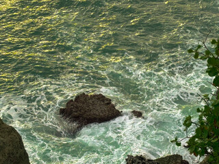 Seascape Embrace: The scene showcases the meeting of textured seawater and the rough stone creating a contrast that captivates the eye and evokes a sense of adventure and serenity.