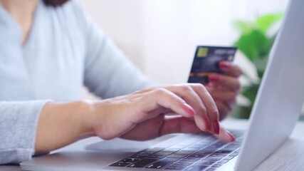 woman’s hands holding a credit card while typing on a keyboard, making a secure online payment, digital shopping transaction, internet banking, and e-commerce purchase with financial technology  - Powered by Adobe