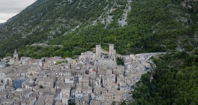 Aerial view of Castello Caldora and the historic town nestled below, contrasting with the green mountains, Pacentro, Abruzzo, Italy.