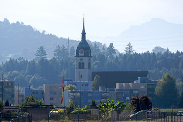 Scenic landscape with bell tower of St. Mauritius church at Swiss city of Emmen on a sunny summer...