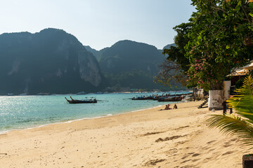 A beautiful Phi Phi Island beach Thailand landscape featuring a traditional boat set against majestic mountains