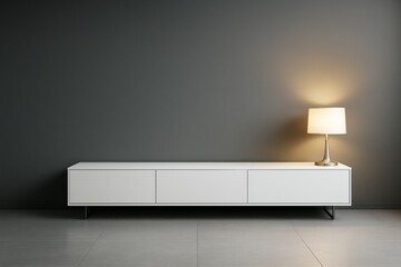 Minimalist modern interior with white cabinet and lit table lamp against dark wall in empty contemporary room with tiled floor and soft lighting.