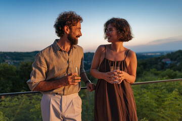 Couple enjoying cocktails on a panoramic terrace at sunset