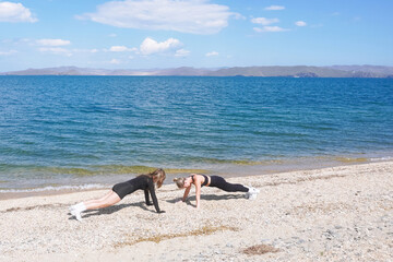 Cardio training session on a sandy beach by the lake during a sunny day