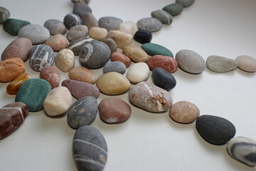 Rays from the sun pattern laid out from smooth pebbles on white

