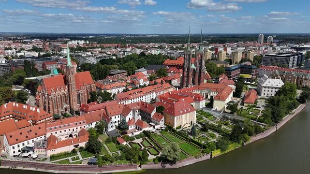 Drone video showing Ostr&oacute;w Tumski in Wrocław, Cathedral of St. John the Baptist, red rooftops, Oder River, historic old town.