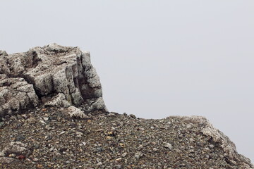 Rock mountain overlooking cloudy valley 