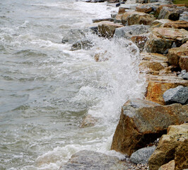 Splashing sea surf hitting rocks on the beach