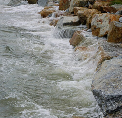 Splashing sea surf hitting rocks on the beach