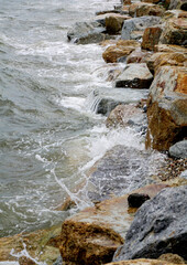 Splashing sea surf hitting rocks on the beach