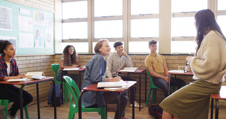 High school, teacher or students with lesson in classroom for exam support, attention or teaching. Teenager, group and listening to woman for education, coursework feedback and assignment preparation
