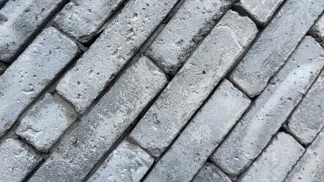 Video of gray brick blocks stacked diagonally with rough textures and visible construction details.
