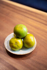 Yummy tasty yellow limes fruit on a plate on a wooden table