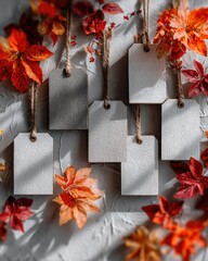 Blank tags hang amidst autumn leaves, casting shadows on a textured surface
