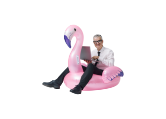 Cheerful businessman riding an inflatable toy and using a laptop