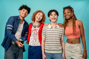 Portrait of diverse Generation Z friends posing on isolated blue screen. 