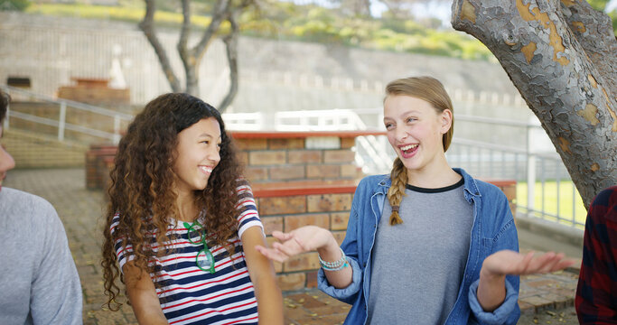 Outdoor, students and laughing with friends, high school or humor for story, discussion and bonding. Happiness, teenager and listening to funny joke, girl and conversation with group and education - Powered by Adobe