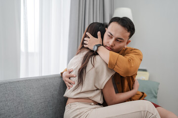 Fototapeta premium A couple sharing a heartfelt hug, providing emotional support in a cozy setting.