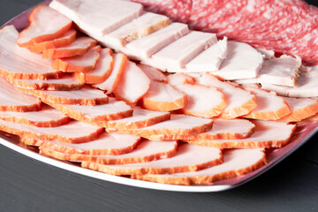 A plate of meat with a variety of different meats on it. The plate is on a table