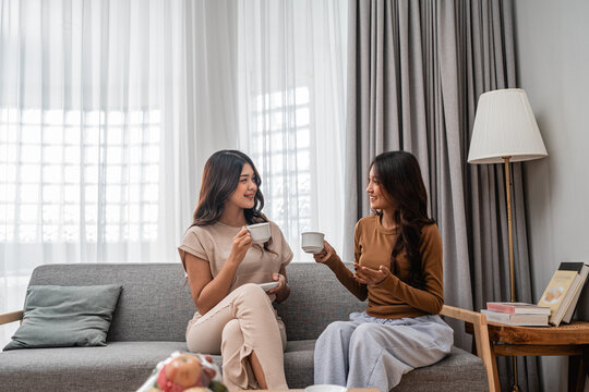 Two close friends joyfully sharing delightful moments over coffee in a stylish living room space - Powered by Adobe