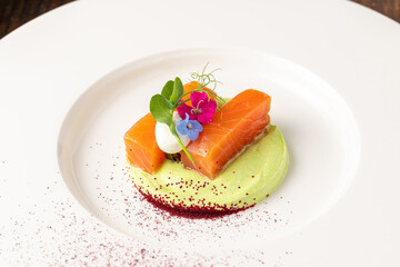 Gourmet salmon fillet with green puree and edible flowers