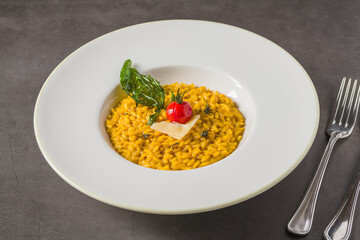 Porcini mushroom risotto on a white porcelain plate on a stone table