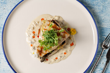 Grilled sea bream fillet served with creamy white sauce