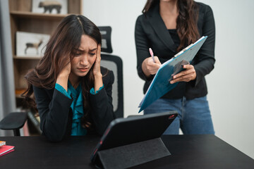 A visibly stressed woman sitting at a meeting table, struggling to manage her tablet effectively