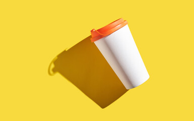 Floating white coffee cup with orange lid on yellow background casting shadow.