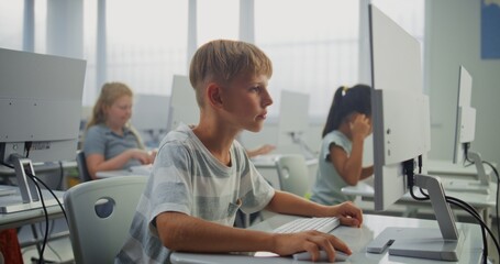 Fototapeta premium Smart Young Boy Using Computer, Doing Creative 3D Design Project. African American Teacher Helping Elementary School Children in Learning Coding During Digital Programming Lesson. STEM Education.