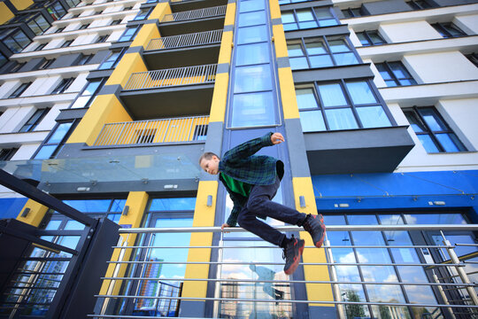 a teenager mid action as they engage in parkour against the backdrop of towering skyscrapers in an urban setting. The energy and agility displayed in the leap reflect the thrill of the sport