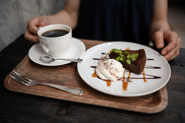 woman holding a cup of coffee with a gado chocolat cake