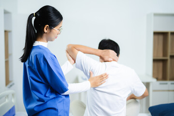 Fototapeta premium Nurse provides back massage to senior patient in clinic. Perfect for physiotherapy, rehabilitation, aging care, wellness, pain relief, and professional healthcare themes.