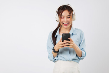 Game fun and game focus as Asian woman with headphones smiles using mobile phone to play or watch...