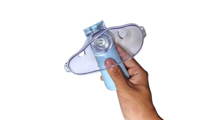 A hand holding a portable nebulizer with a blue body and clear mask, designed for respiratory...