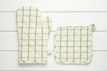 Oven glove and potholder on white wooden table, flat lay