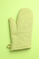 One oven glove on green background, top view