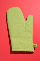 One oven glove on red background, top view