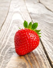 Single ripe strawberry on weathered wood