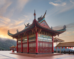 Obraz premium Chin Swee Caves Temple, Genting Highlands, Pahang, Malaysia. Traditional Chinese architecture with ornate roof and red pillars at sunrise