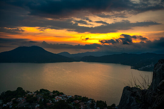 Sunset light over Valle de Bravo lake in Mexico from La Pena, dramatic clouds and water reflections symbolizing serenity, tourism, travel and cultural identity