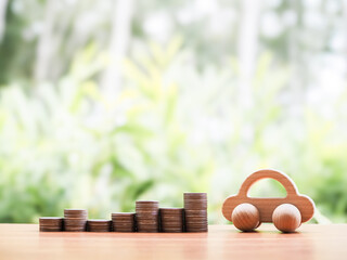 Wooden toy car and stack of coins. The concept of saving money to success transportation, Car loan...