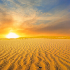 wide hot sandy desert at the dramatic sunset