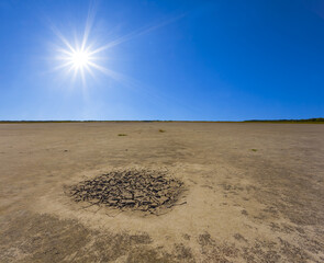 dry cracked earth under a hot sparkle sun