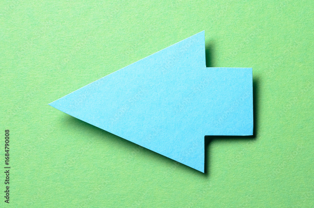 Poster blue cut out blank paper cardboard arrow direction sign with copy space for text on green background