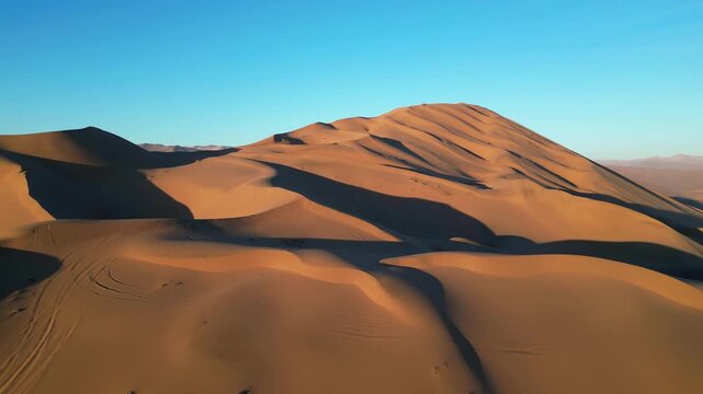 Drone shot of the Whale Dune in the Atacama, showing vast desert curves painted with shimmering light and shadow.