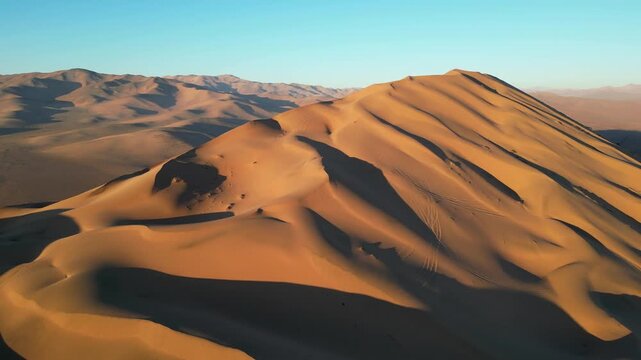 Golden-hour panorama of Duna la Ballena, its vast parabolic form etched with dark streaks and luminous highlights across the Atacama.