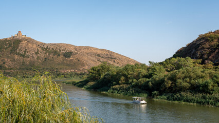 Tourist cruise boats sightseeing tours along Mtkvari Kura river in historic city of Mtskheta, Georgia