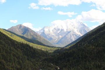 Naklejka premium Majestic snow-capped mountain peaks pierce a clear blue sky Yala Snow Mountain Sichuan, China